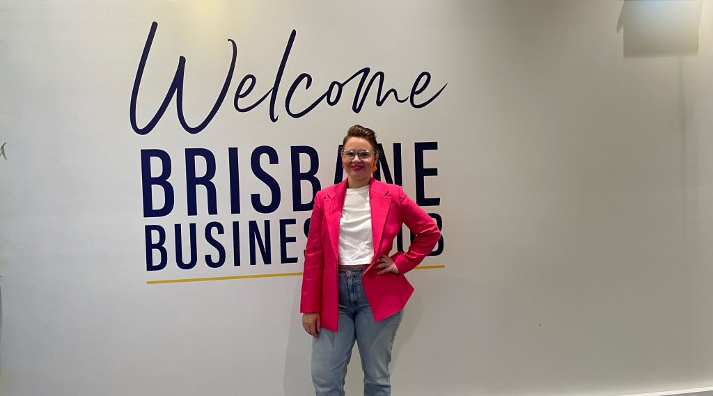 Rachael Bosnjak, posing in from of the Welcome to the Brisbane Business Hub mural